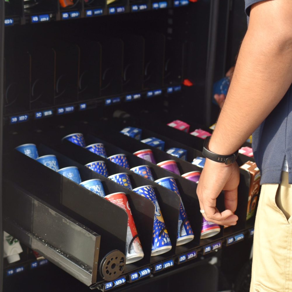 local-snack-vending-machine-being-stocked-by-suppl-2022-11-08-08-47-46-utc